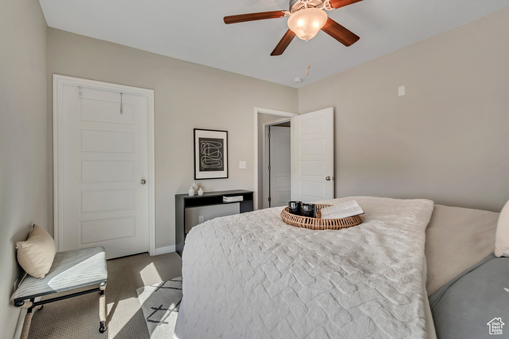 Carpeted bedroom featuring a ceiling fan