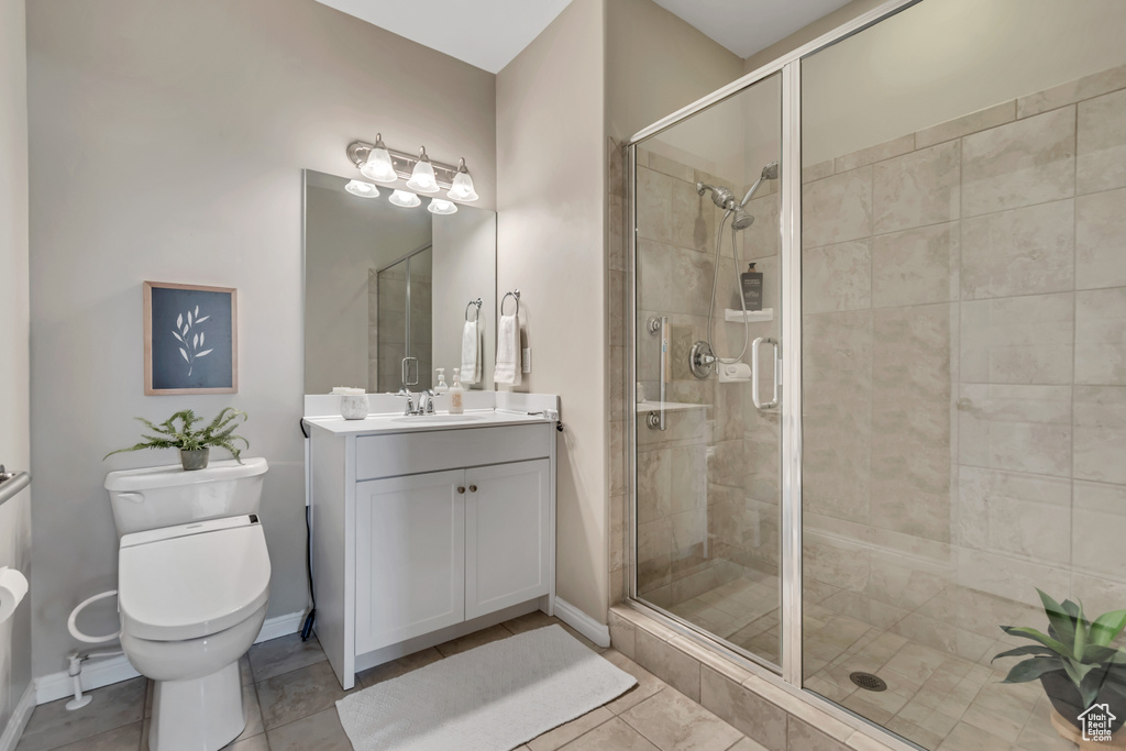Full bath featuring vanity, a stall shower, and tile patterned floors