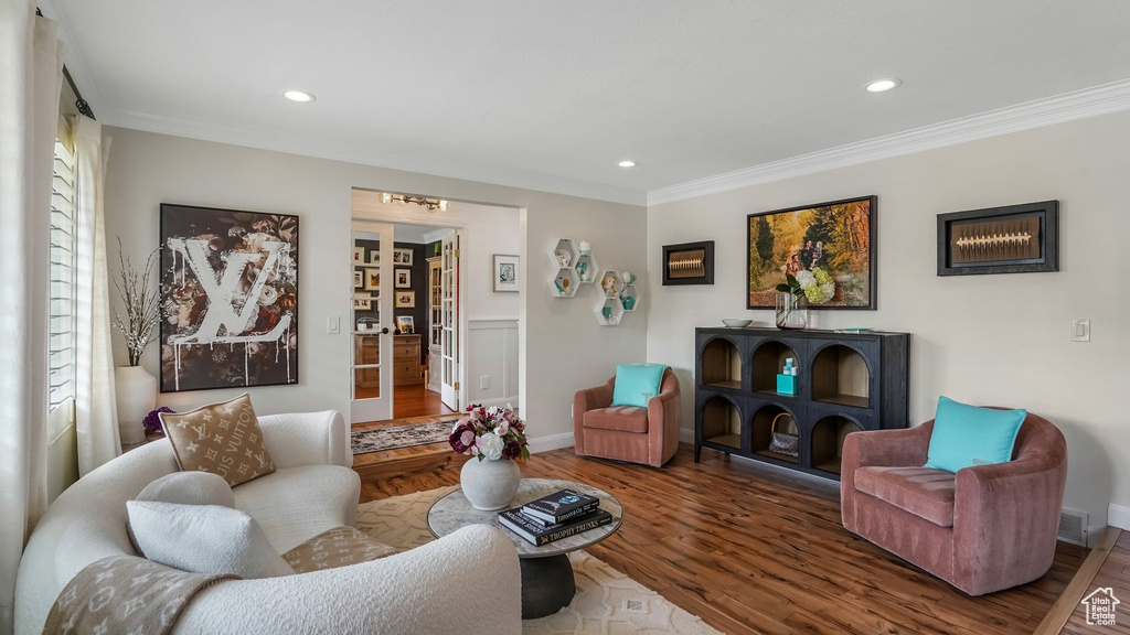 Living area with ornamental molding, wood finished floors, recessed lighting, and a chandelier