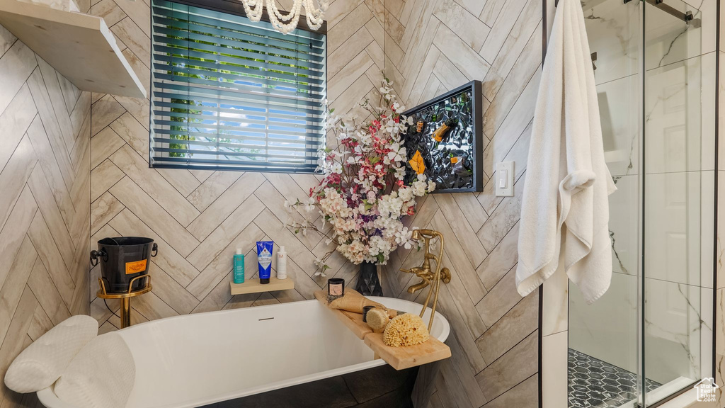 Bathroom with a freestanding tub, a stall shower, and a chandelier