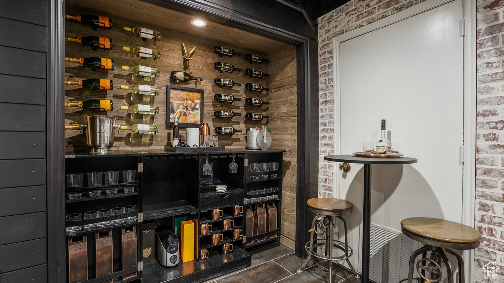 Wine cellar with brick wall and dark tile patterned floors