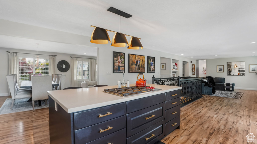 Kitchen featuring open floor plan, light wood-style floors, stainless steel gas stovetop, light countertops, and recessed lighting
