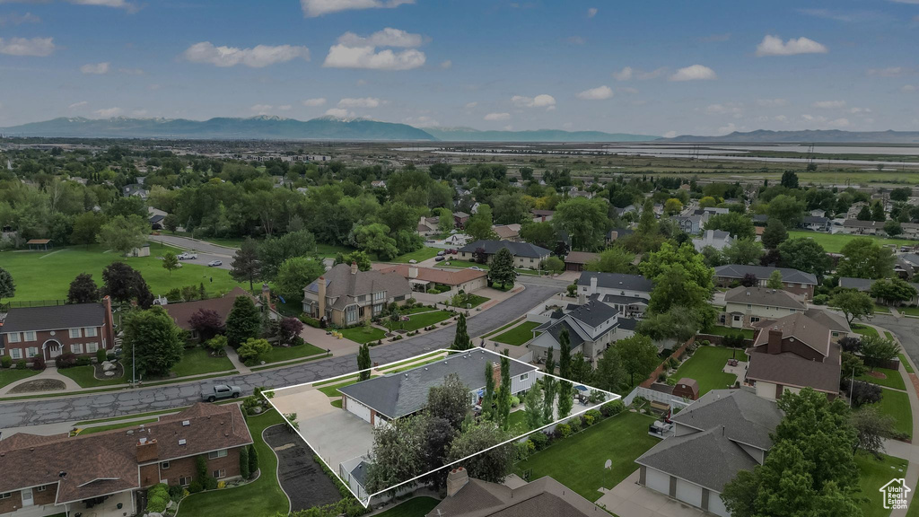 Aerial perspective of suburban area featuring property parcel outlined and a mountain backdrop