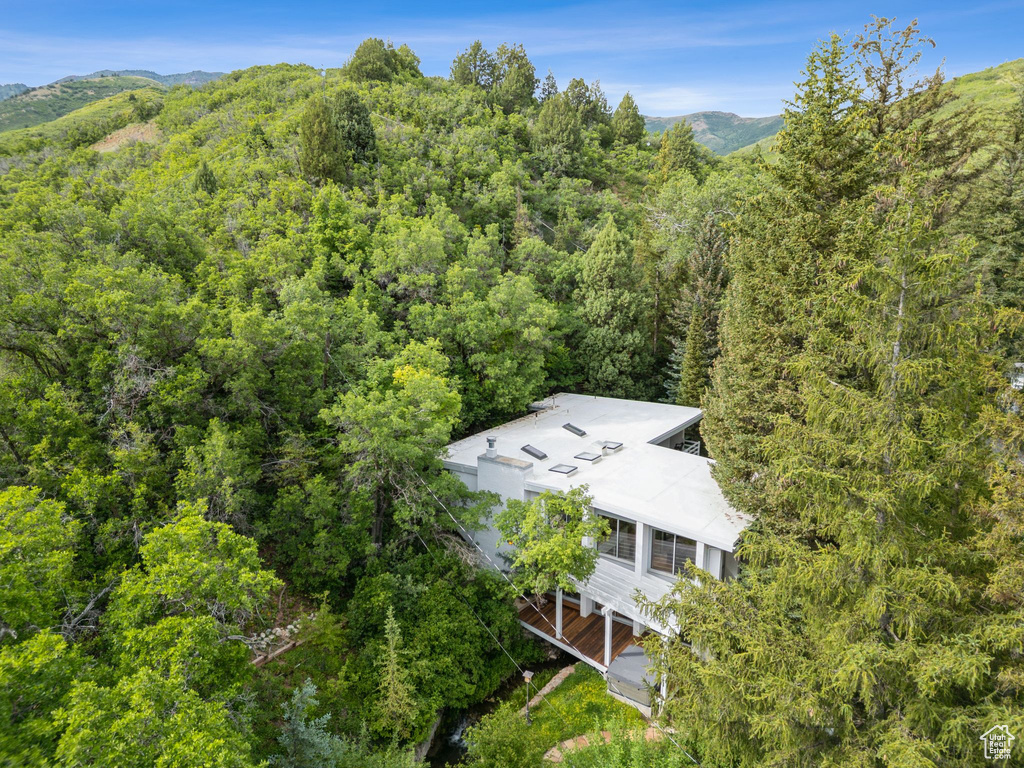 View of subject property featuring a heavily wooded area and a mountainous background