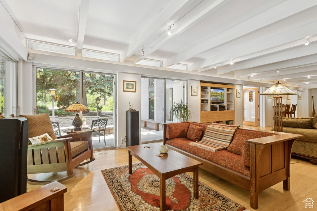Living room featuring light wood-type flooring and beamed ceiling