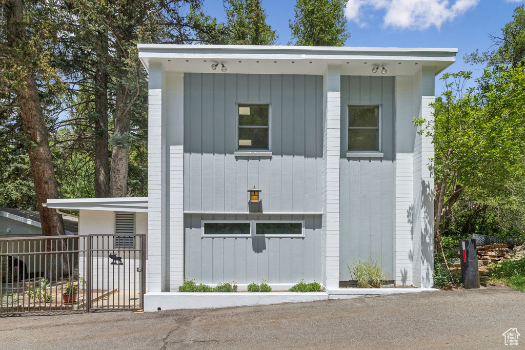 View of front of house featuring board and batten siding and a gate