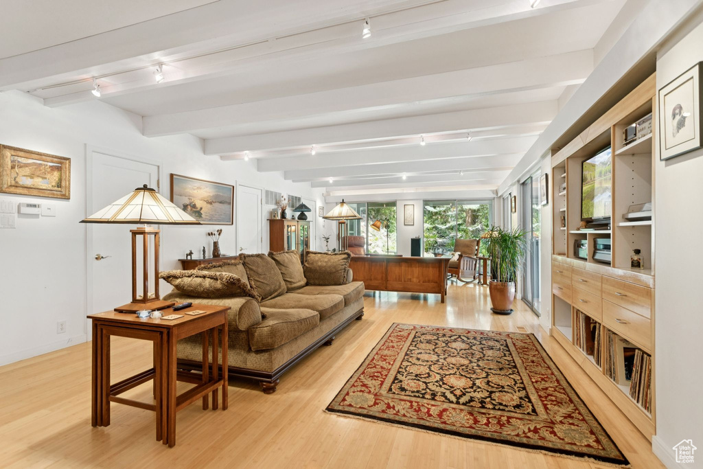 Living area with track lighting, light wood-style flooring, and beamed ceiling