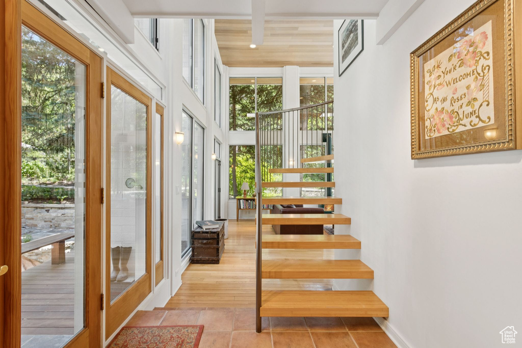 Stairs with plenty of natural light and tile patterned floors
