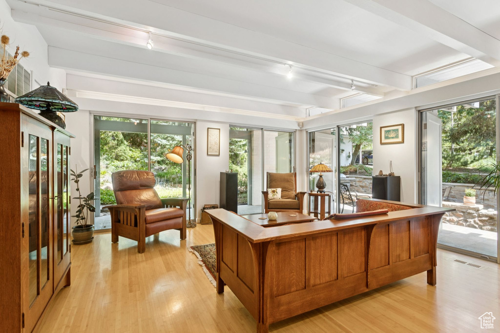 Home office featuring rail lighting, light wood-type flooring, and beamed ceiling