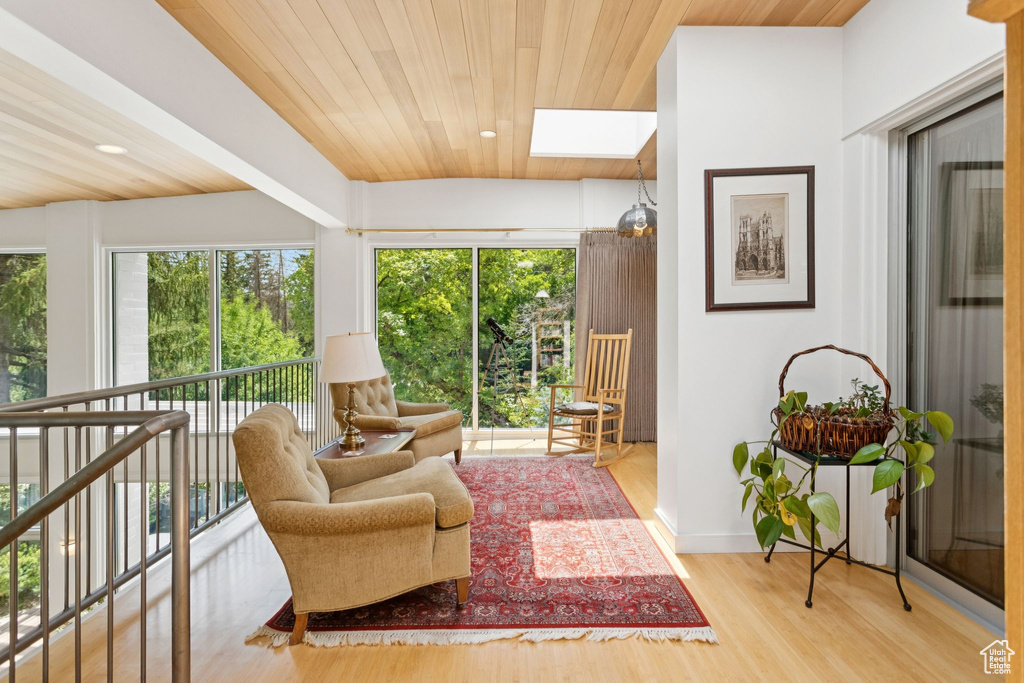 Living area with wood ceiling, wood finished floors, and a skylight