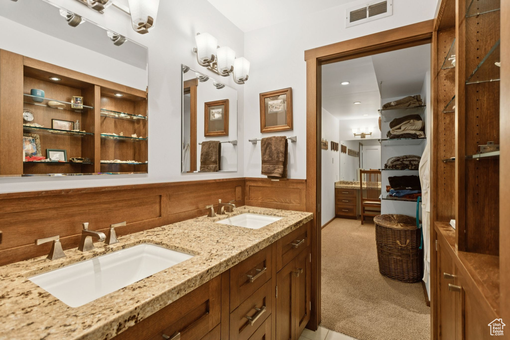 Bathroom featuring double vanity and wainscoting