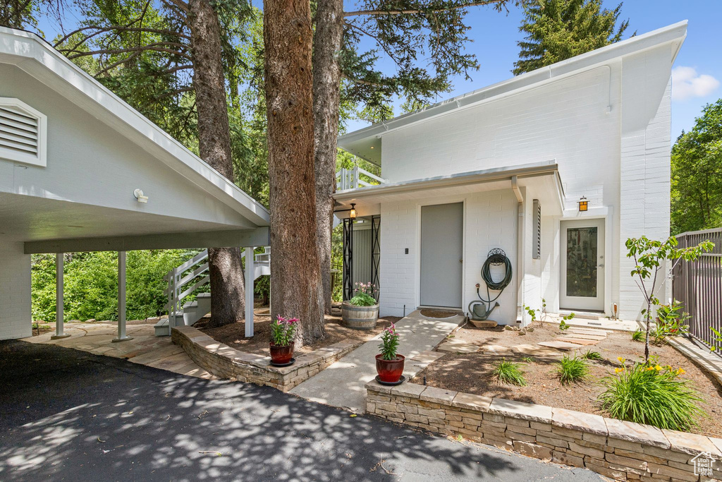 View of front of property with stairway, a patio area, and brick siding