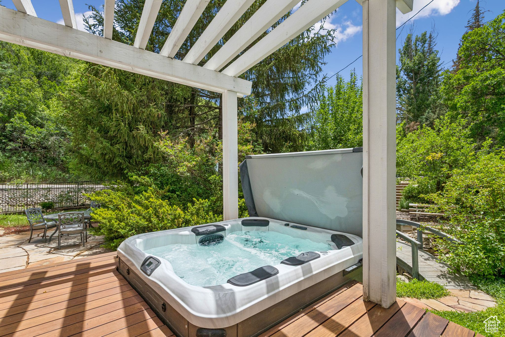 Deck with a covered hot tub and outdoor dining area