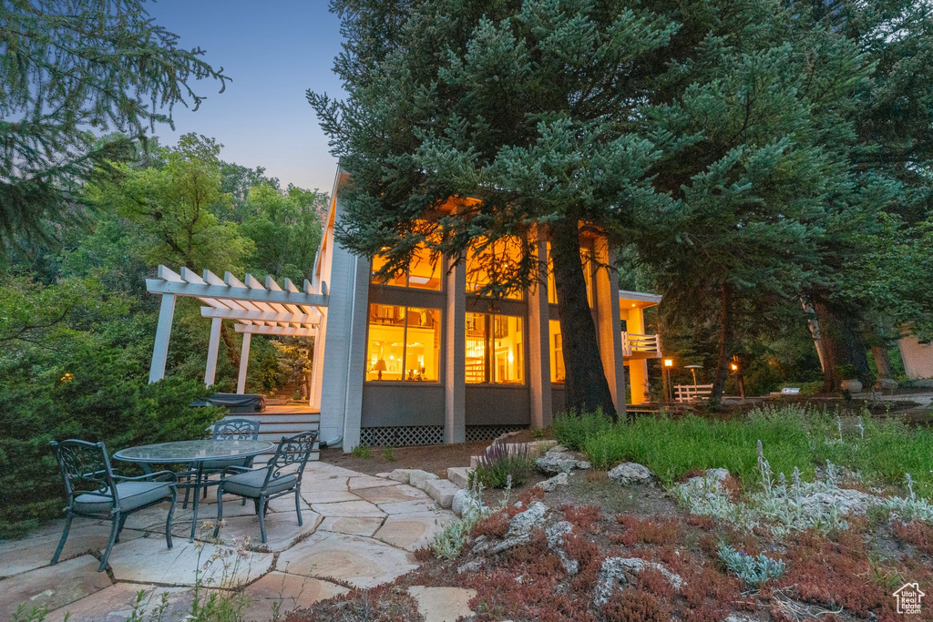 Back of property featuring a pergola, a patio, and outdoor dining area