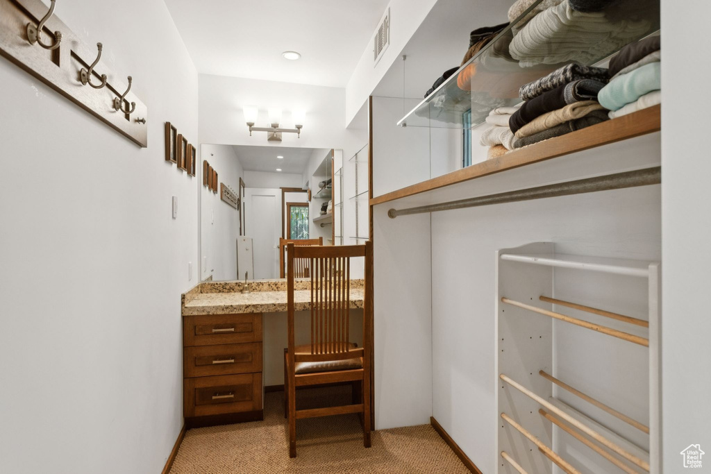 Walk in closet featuring light colored carpet