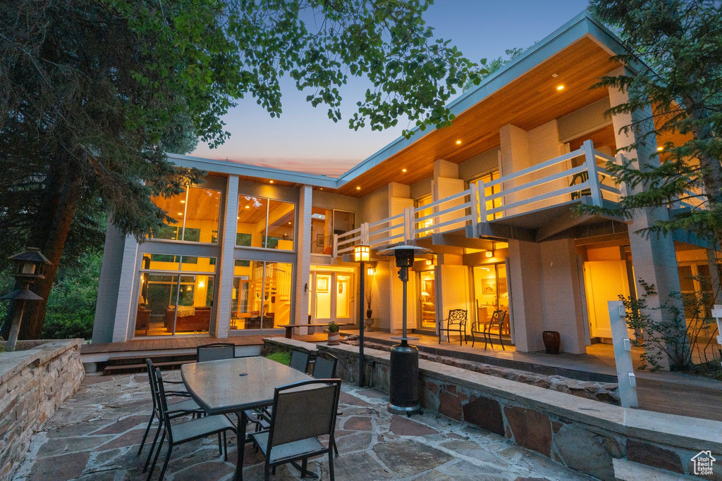 Rear view of property with a balcony, a patio area, and outdoor dining space