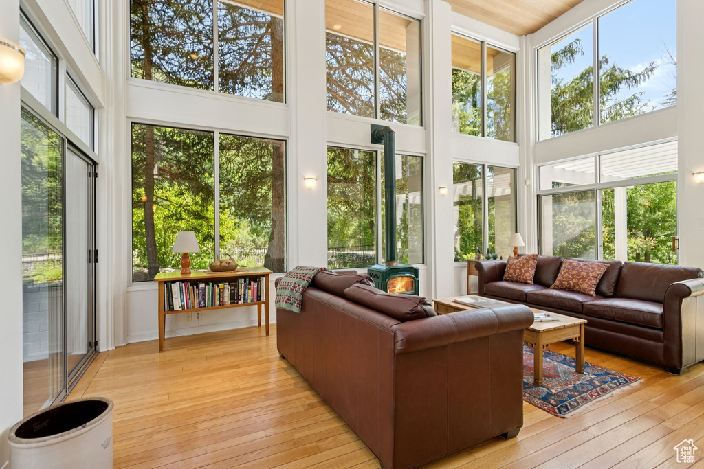 Sunroom / solarium featuring a high ceiling, wood-type flooring, and a deck