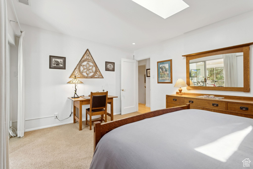 Bedroom featuring a skylight and light carpet