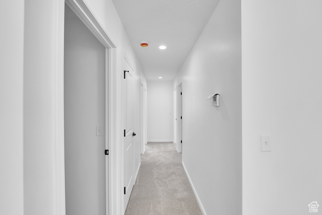 Corridor with recessed lighting and light carpet