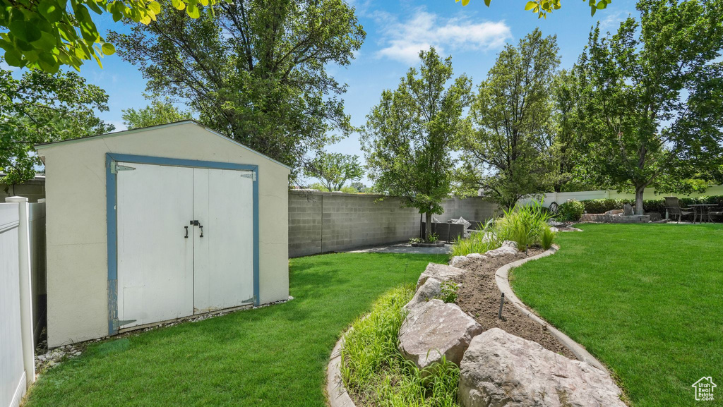 Fenced backyard featuring a storage shed