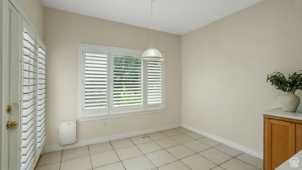 Unfurnished dining area with baseboards and light tile patterned floors