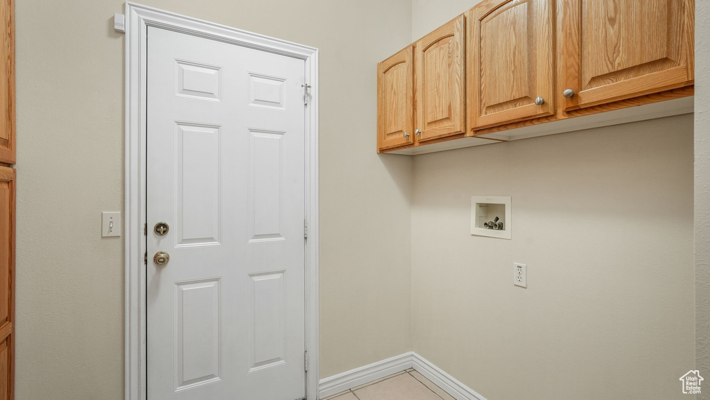Laundry room with cabinet space, washer hookup, and light tile patterned flooring