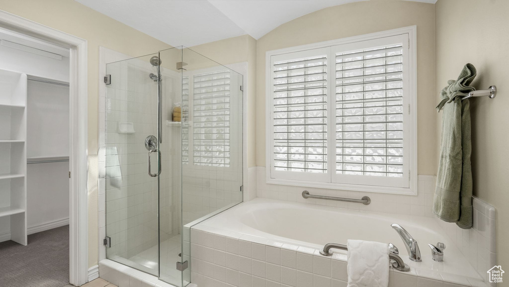 Full bath featuring a stall shower, a bath, and a walk in closet