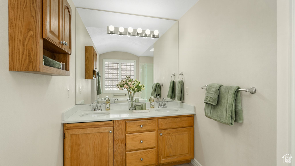 Bathroom with double vanity, an enclosed shower, and vaulted ceiling