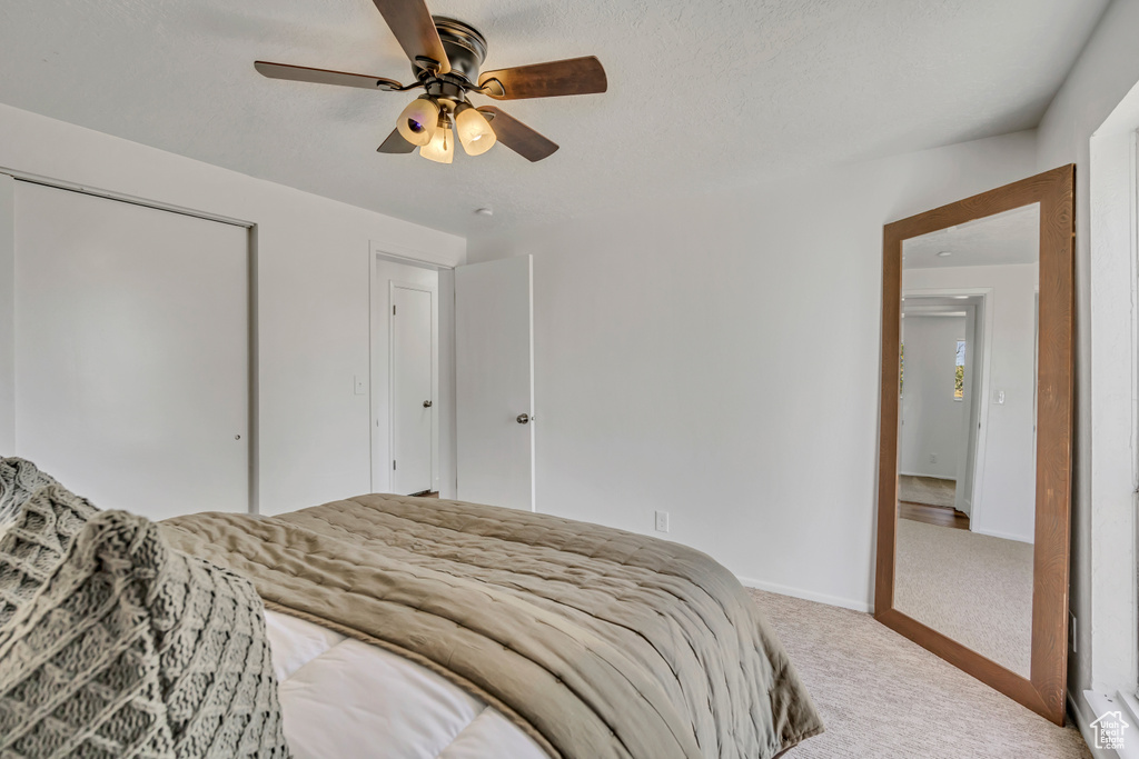 Bedroom featuring carpet, a ceiling fan, and a closet