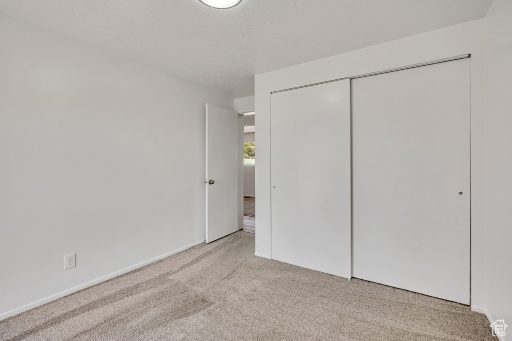 Unfurnished bedroom featuring carpet flooring and a closet