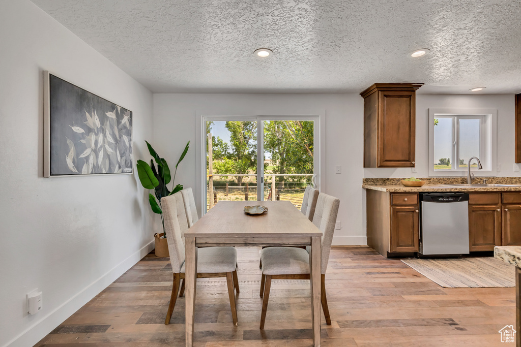Dining area featuring a textured ceiling and light wood-type flooring