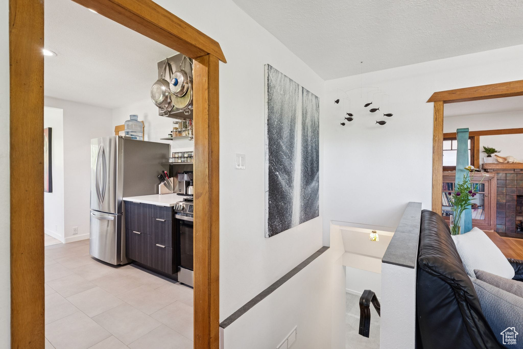 Hallway featuring baseboards and light tile patterned flooring