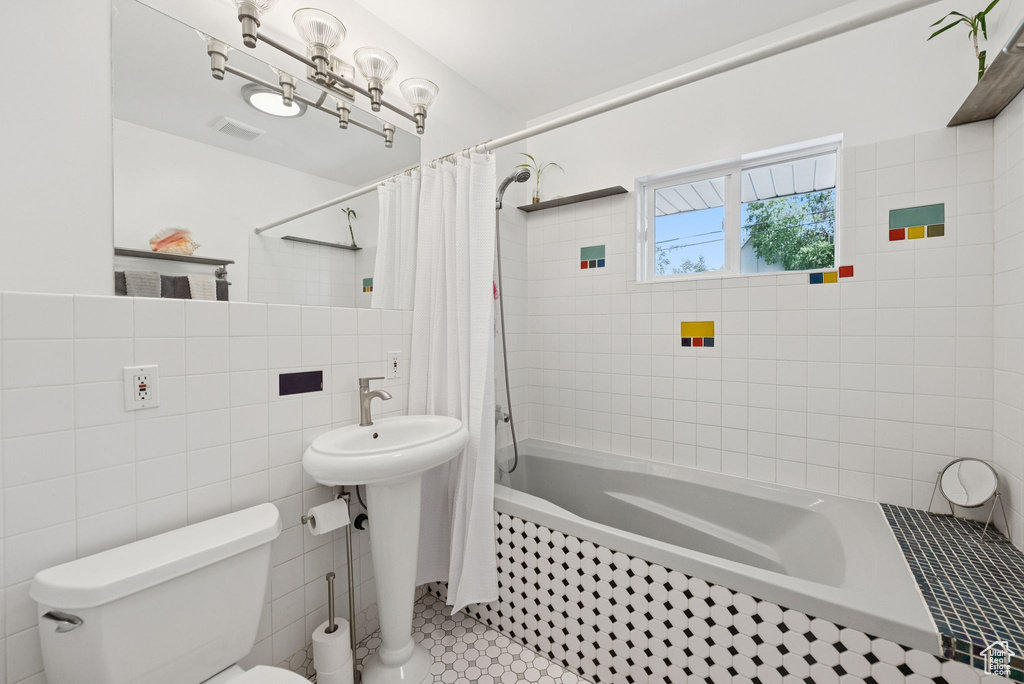 Full bathroom with tile walls, tiled shower / bath combo, and tile patterned floors