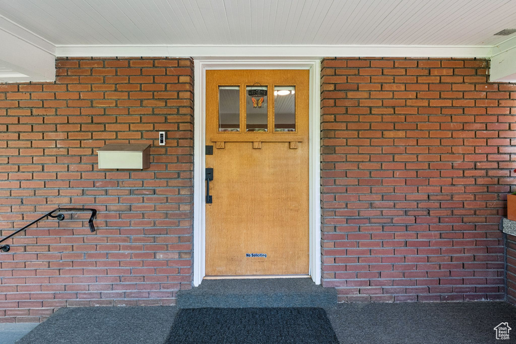 Doorway to property with brick siding