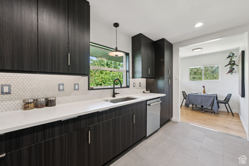 Kitchen featuring dishwasher, light countertops, decorative backsplash, pendant lighting, and recessed lighting