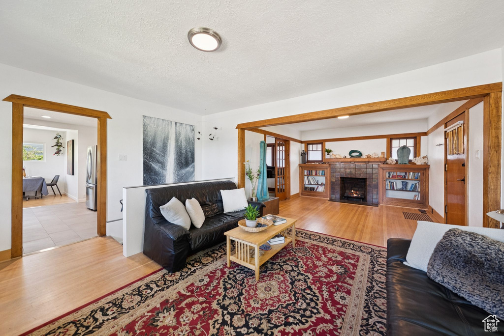 Living area with wood finished floors, a fireplace, and a textured ceiling