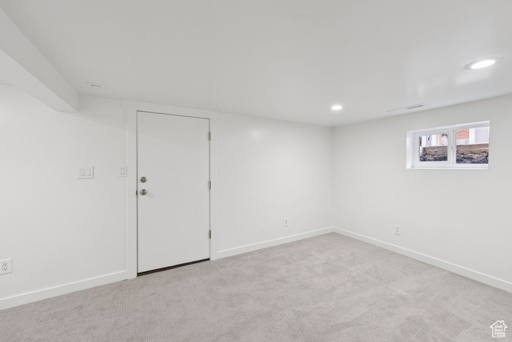 Below grade area with light colored carpet and recessed lighting