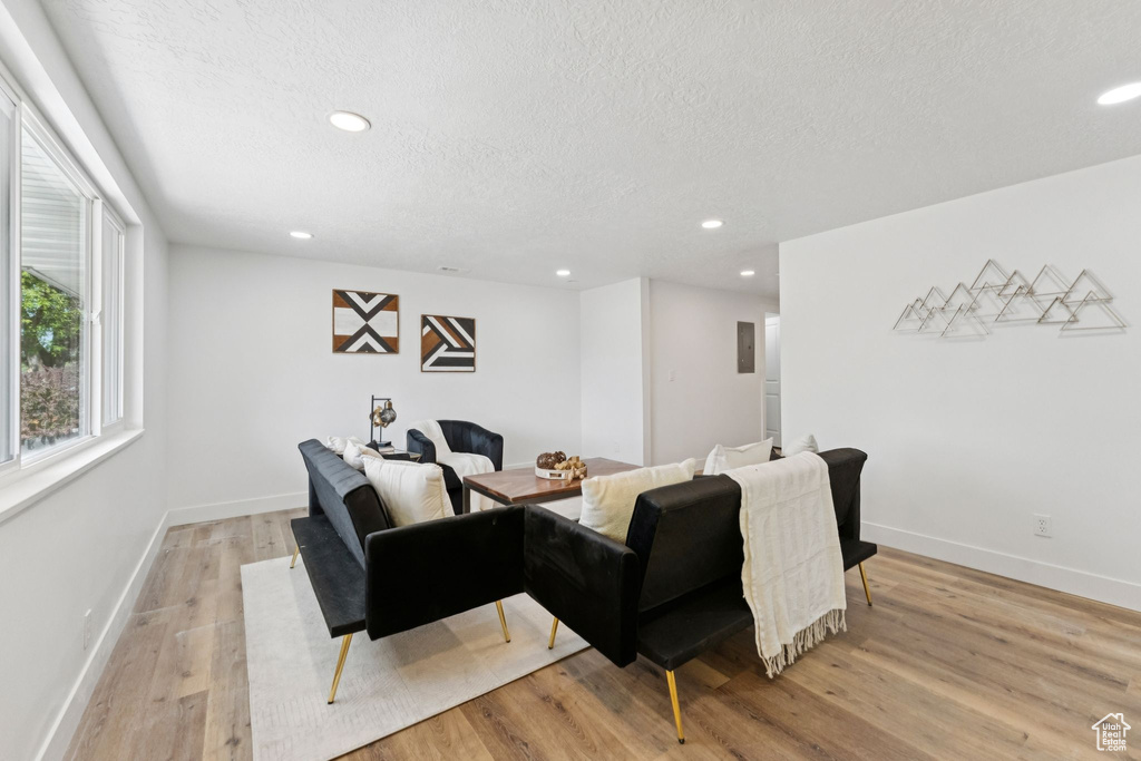 Living room featuring a textured ceiling, recessed lighting, and light wood finished floors