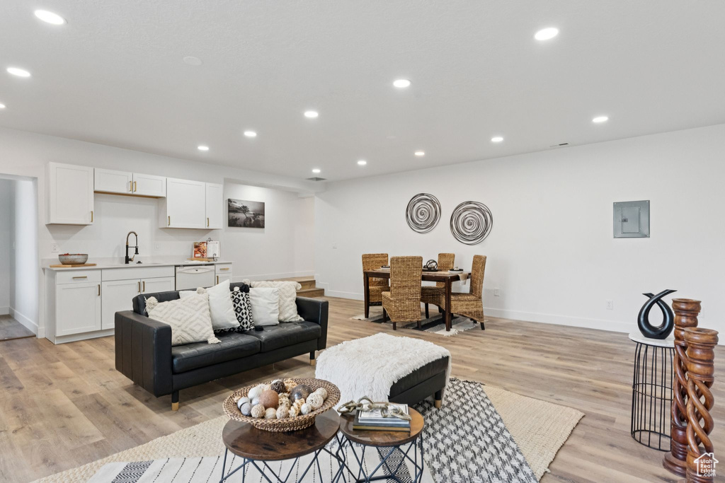 Living room featuring recessed lighting, light wood-style floors, and electric panel