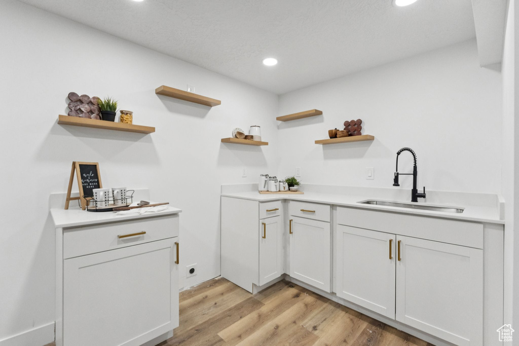 Kitchen with open shelves, light wood-style flooring, recessed lighting, light countertops, and white cabinetry