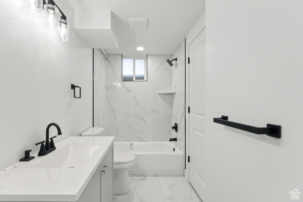 Bathroom featuring vanity, marble finish floors, and tub / shower combination