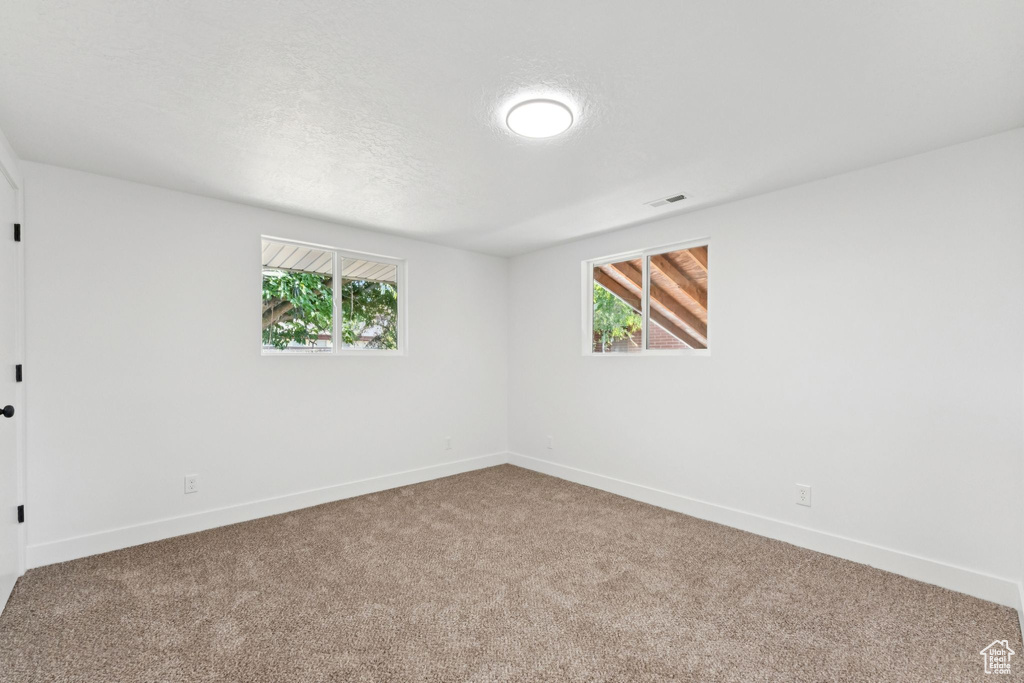 Spare room featuring carpet and baseboards