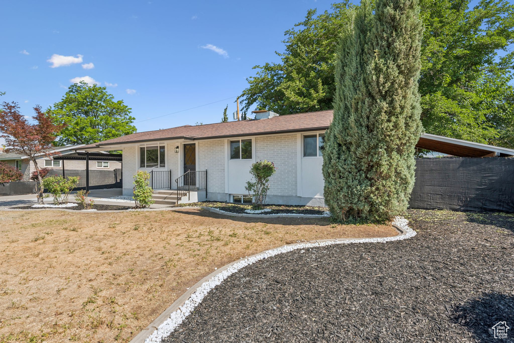 Ranch-style home featuring brick siding and an attached carport