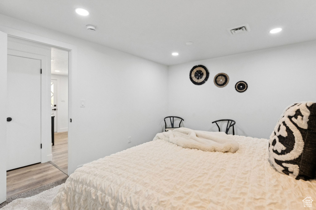 Bedroom with wood finished floors and recessed lighting