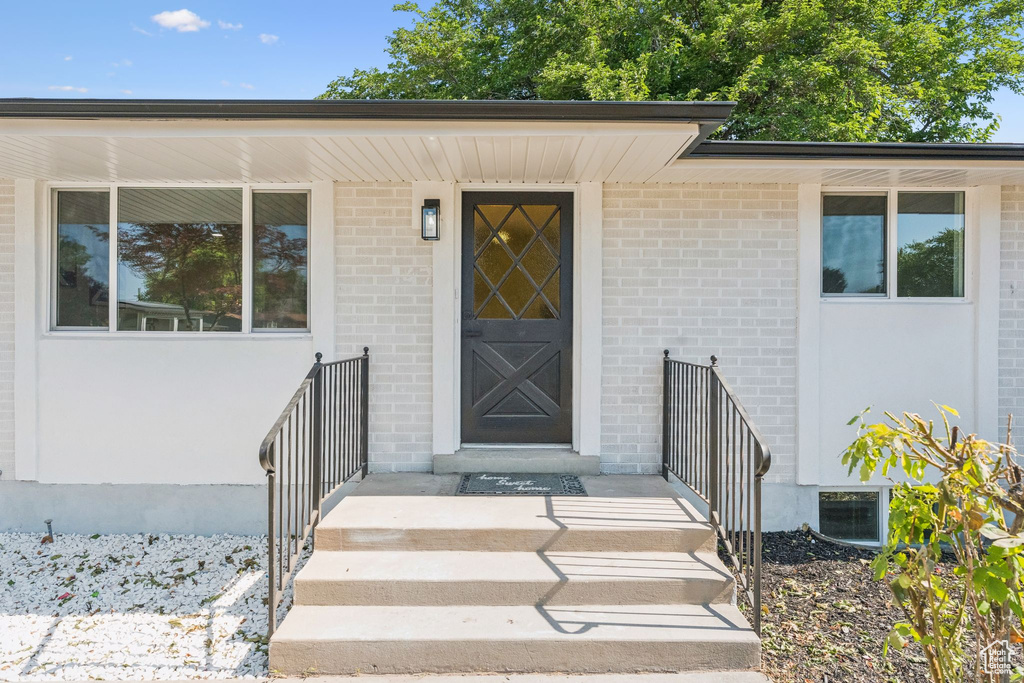 Doorway to property with brick siding and stucco siding