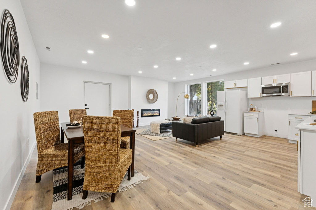 Dining room with light wood-style floors and recessed lighting