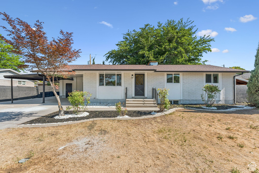 Single story home with brick siding, an attached carport, and driveway