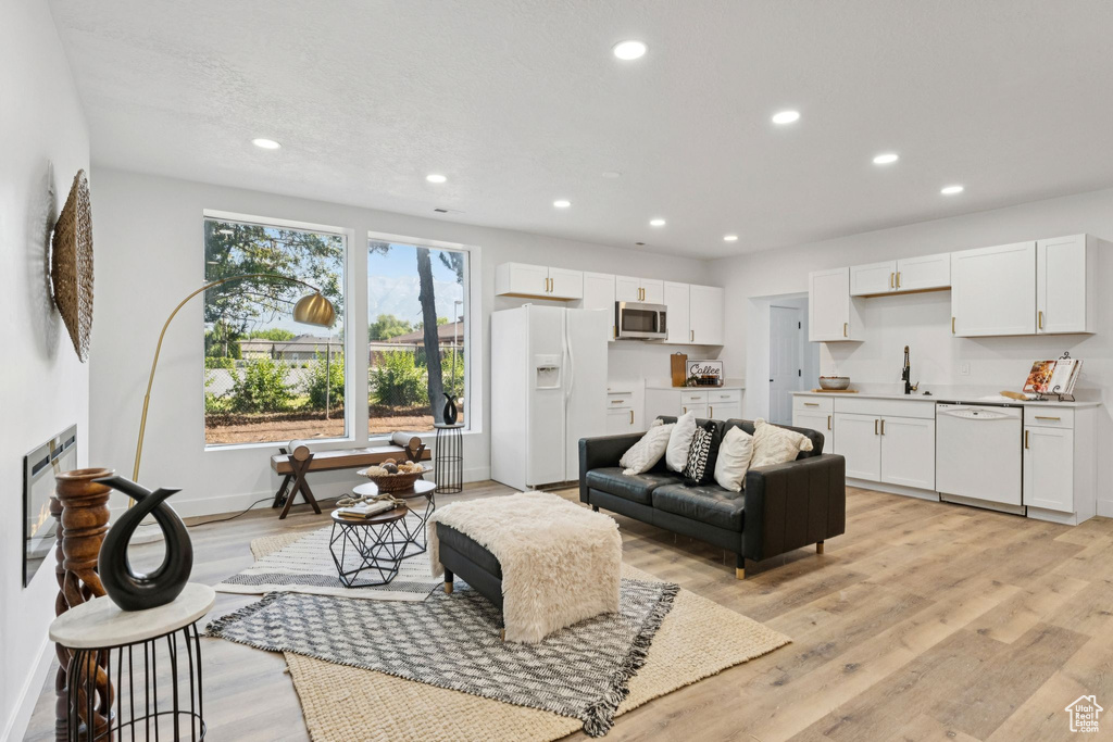 Living area with recessed lighting and light wood finished floors