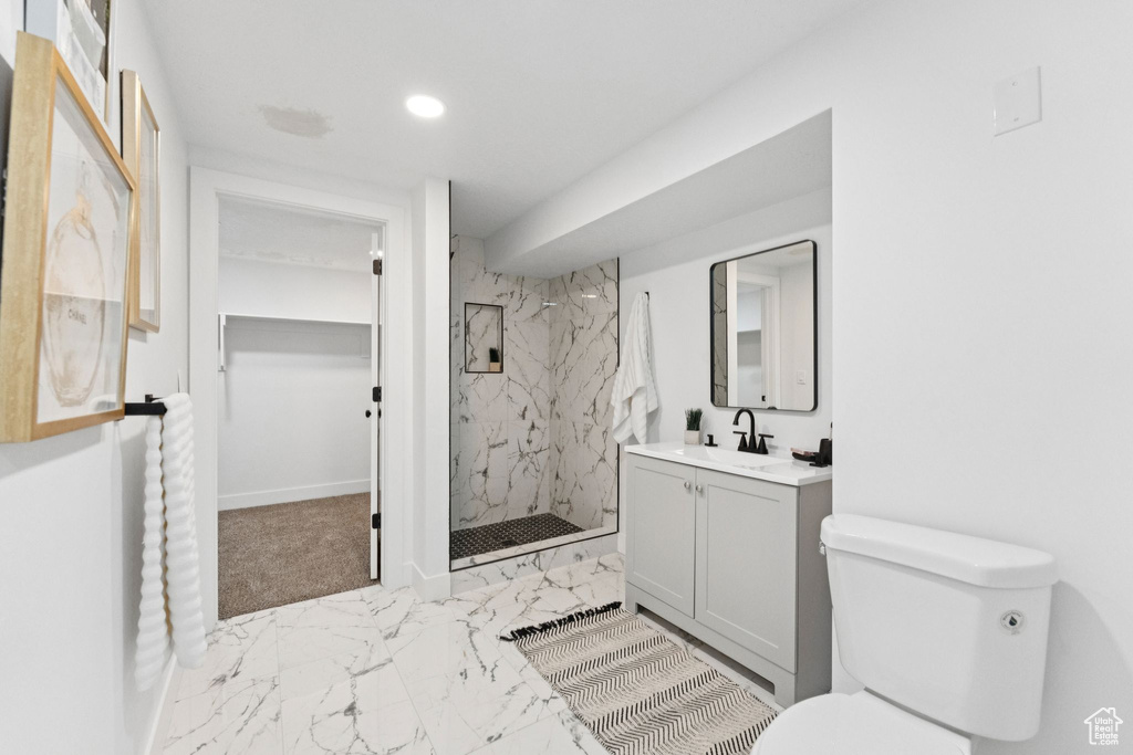 Full bathroom with marble look tile flooring, a marble finish shower, vanity, recessed lighting, and a spacious closet