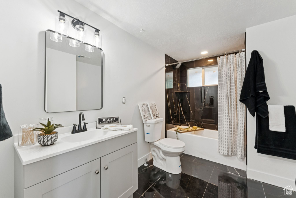 Bathroom with vanity, shower / bathtub combination with curtain, a textured ceiling, and recessed lighting